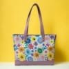 Front view of a floral canvas tote bag with premium leather handles and accents."