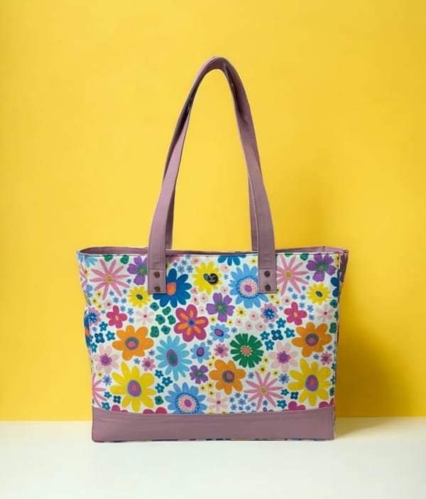 Front view of a floral canvas tote bag with premium leather handles and accents."