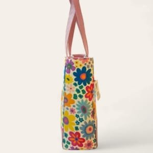 Side view showcasing the leather accents and spacious design of the floral canvas tote bag