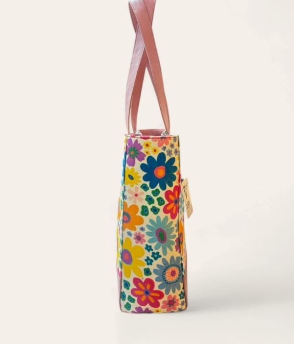 Side view showcasing the leather accents and spacious design of the floral canvas tote bag