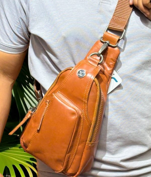 Model wearing the Hudson Sling Bag in brown, showcasing its versatility and style